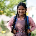 Cheerful Indian schoolgirl in uniform smiling outdoors in Lucknow, India.